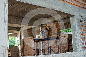 Construction worker placing bricks on cement for building exterior