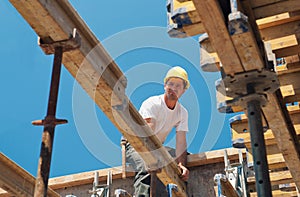 Construction worker placing formwork beams