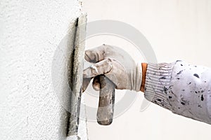 Construction worker plastering and smoothing concrete wall with cement