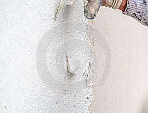 Construction worker plastering and smoothing concrete wall with cement