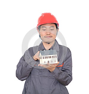 Construction worker pointing at small house model in hand