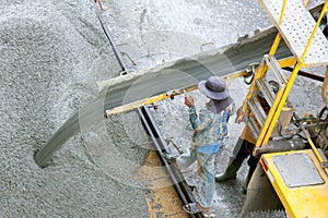 Construction worker pouring concrete from cement truck, people worker