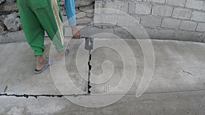 Construction worker pouring hot melted asphalt between road junction blocks