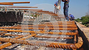 Construction worker is pouring reinforced concrete in long wooden mold