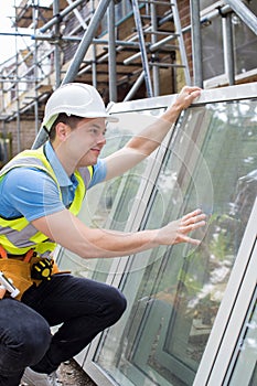 Construction Worker Preparing To Fit New Windows