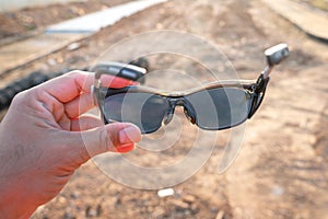 A construction worker is preparing to wear an operation safety glass