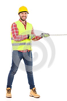 Construction worker pulling a chain