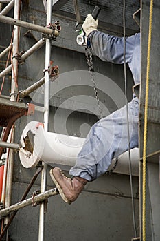 Construction Worker Ratcheting Pipe into Place
