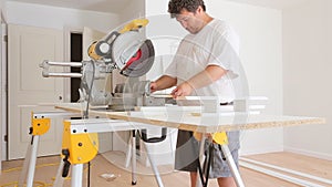 Construction worker remodeling home Carpenter cutting wooden trim board on with circular saw.