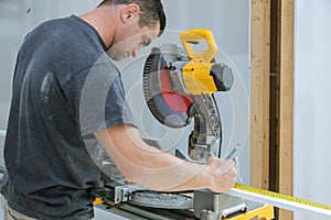 Construction worker remodeling home Carpenter cutting wooden trim board on with circular saw