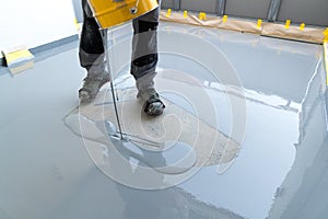 Construction worker renovates balcony floor and pours watertight resin and glue before chipping and sealing