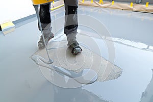 Construction worker renovates balcony floor and pours watertight resin and glue before chipping and sealing