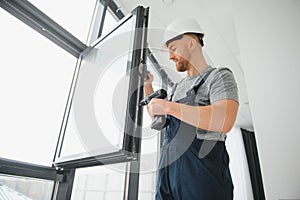 Construction worker repairing plastic window with screwdriver indoors, space for text. Banner design