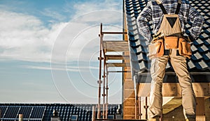 Construction Worker on a Roof Looking Over Building Site in Daylight