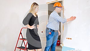 Construction worker showing new house to beautiful young businesswoman