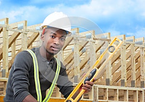 Construction worker on site holding level with white helmet