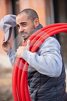 construction worker on site holding red pipe