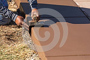 Construction Worker Smoothing Wet Cement With Curb Tool
