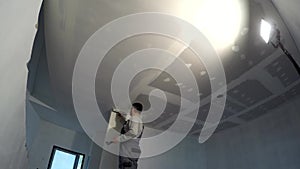 Construction worker spackling apartment ceiling with plaster. Timelapse