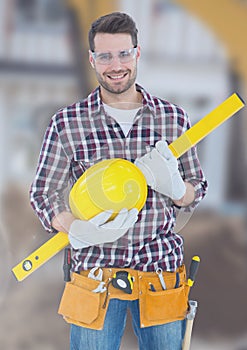 Construction Worker with spirit level in front of construction site
