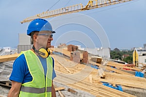 A construction worker stands on the top of the roof and looking at the distance stock photo