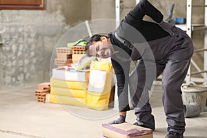 Construction worker suffering back ache lifting a weight