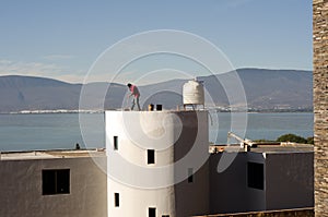 Construction worker sweeping roof top