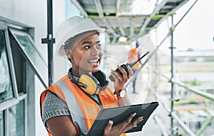 Construction worker with tablet, walkie talkie or radio talking, instructing and checking building progress on
