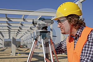 Construction Worker With Tacheometer on Site Under Construction