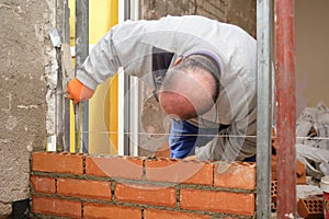 Construction worker taking measurements to build a straight wall