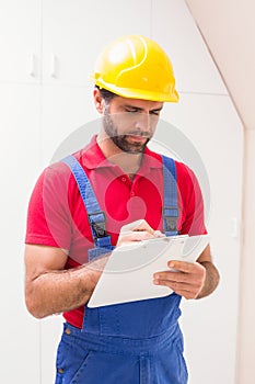 Construction worker taking notes on clipboard