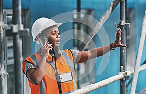 Construction worker talking on a phone call while standing in an empty building. Professional builder discussing plans