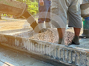 Construction worker team standing on wet concrete floor. Standing for wet cement transfer from truck to steel grid bar o