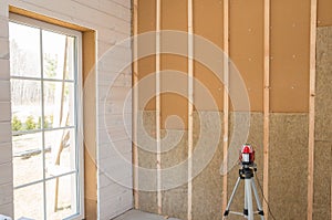 Construction worker thermally insulating eco-wood frame house with wood fiber plates and heat-isolating natural hemp