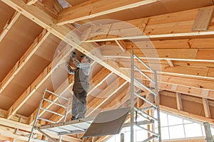 Construction worker thermally insulating eco wooden frame house