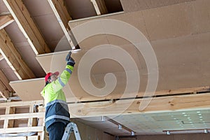 Construction worker thermally insulating eco wooden frame house