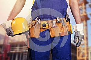 Construction worker with tool belt at building site