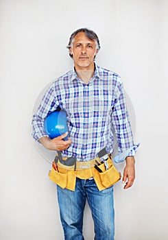 Construction worker with tool belt. Portrait of smart construction worker with protective helmet and tool belt.