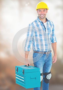 Construction Worker with tool box in front of construction site