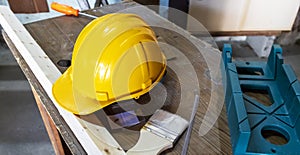 Construction worker tools and a hard hat on a wooden table