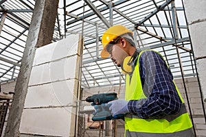 Construction worker use a drill bit,Engineer wearing safety equipment helmet and jacket uses a power drill to mount a aerated