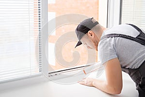 Construction worker use gun silicone tube for repairing and installing window in house