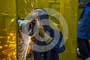 The construction worker use hand grinder .