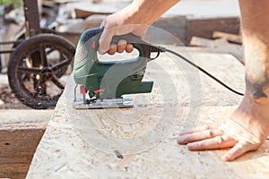 Construction worker use jig saw for cutting a Wood Particle Board or fiberboard. photo