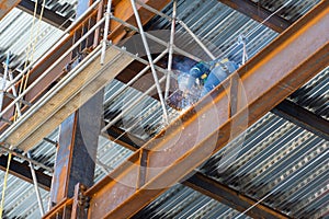 Construction worker using an angle grinder on a scaffold