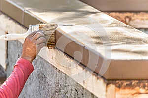 Construction Worker Using Brush On Wet Cement Forming Coping Around New Pool