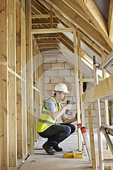 Construction Worker Using Drill On House Build