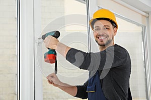 Construction worker using drill while installing window