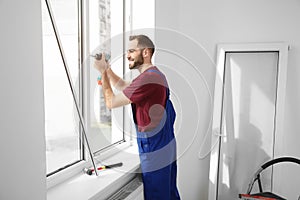 Construction worker using drill while installing window