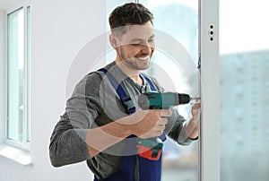 Construction worker using drill while installing window